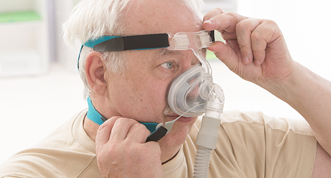 Hombre con CPAP para poder respirar.